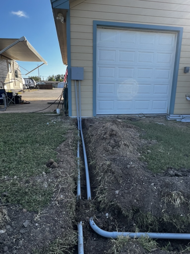 Two conduit runs brought up beside a building as part of network construction.
