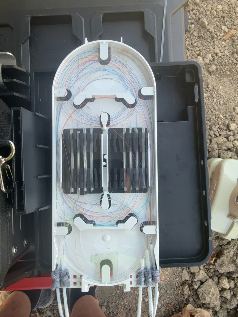 Organized color-coded optical fibers in a splice tray.