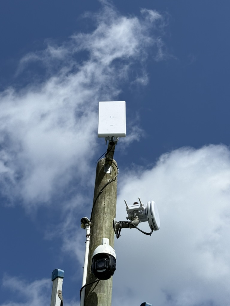 Pole-mounted access point, wireless link, and camera equipment.